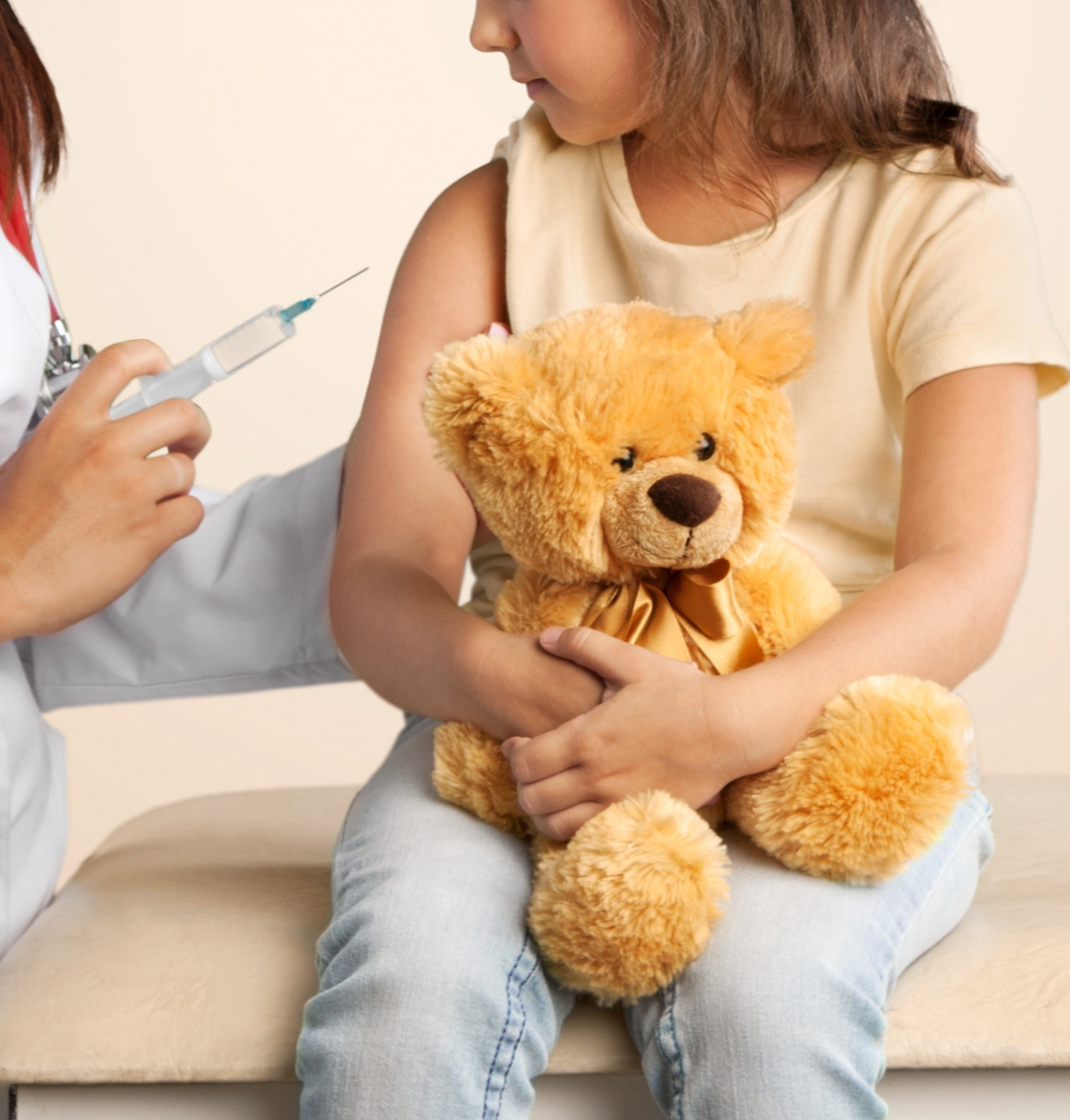 Young woman doctor injecting a little girl
